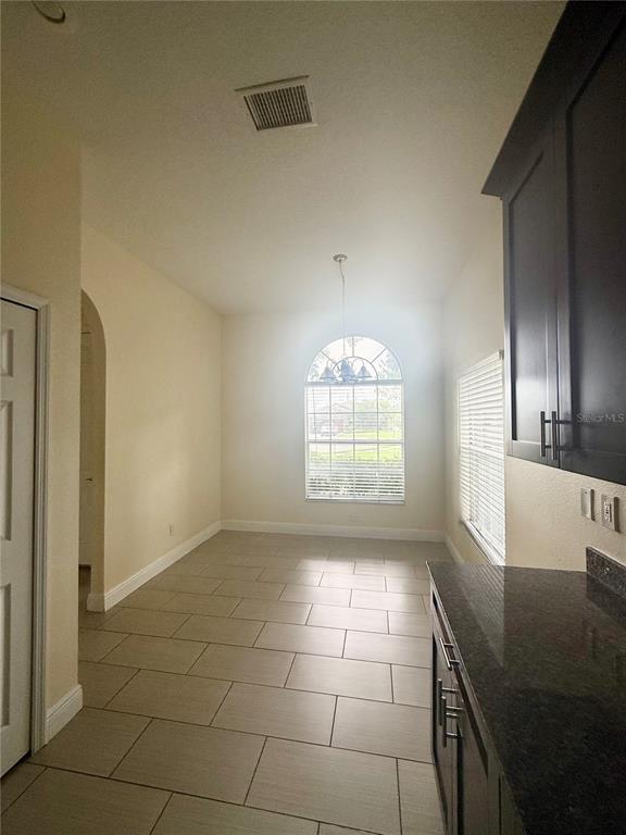A dining area features tile flooring, dark cabinetry, and a large arched window — 4349 CRYSTAL DOWNS COURT, WESLEY CHAPEL, FL