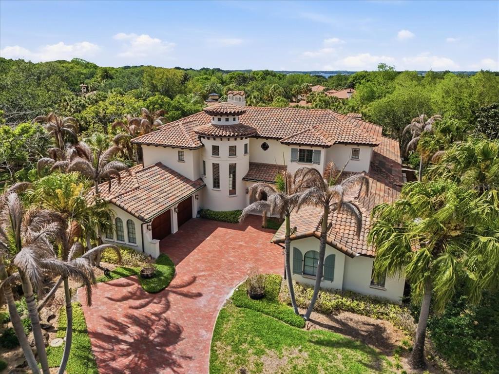 An aerial view of a large Mediterranean-style house with a red tile roof and driveway — 4906 AVIVA GARDEN COURT, WINDERMERE, FL