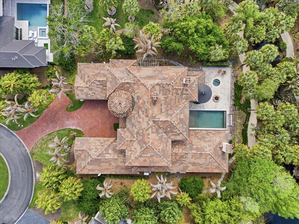 An aerial view of a house with a tiled roof, a pool, and surrounding landscaping — 4906 AVIVA GARDEN COURT, WINDERMERE, FL