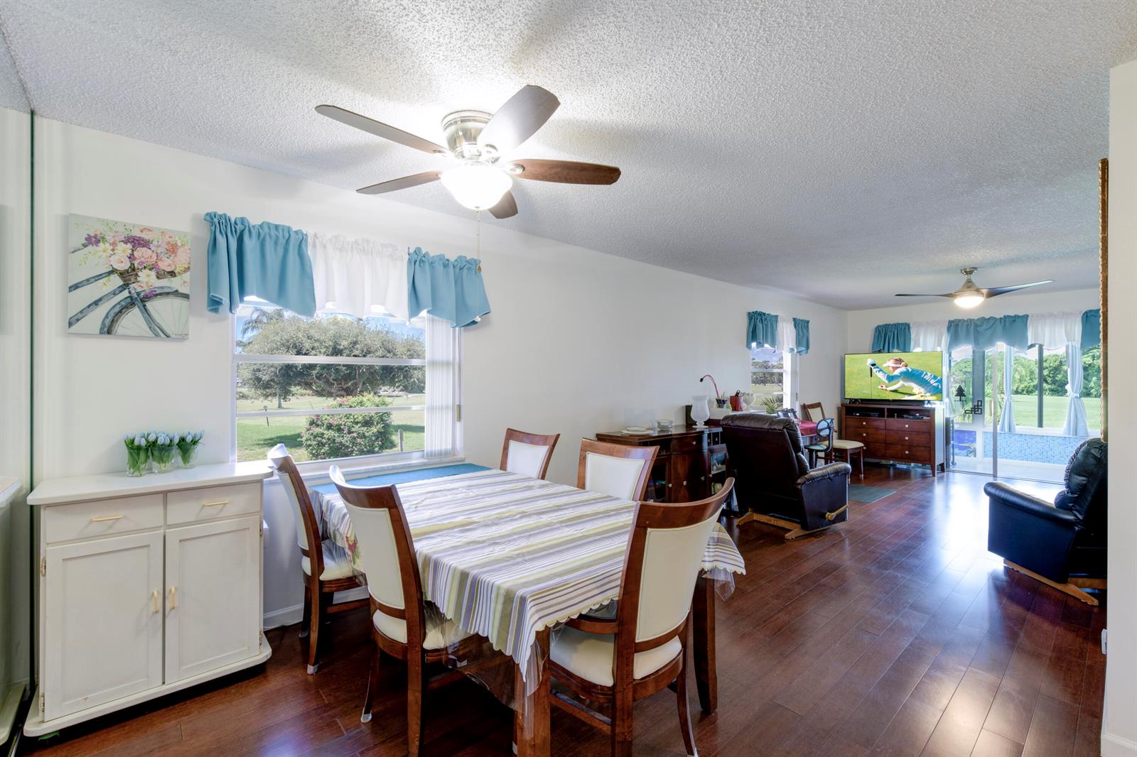 A dining area with a table and chairs opens into a living room with hardwood floors — 1225 NW 21st Street # 1615, Stuart FL 34994, STUART, FL