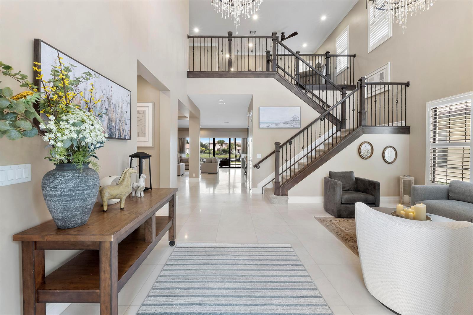 A grand foyer features a staircase, tile flooring, and a view through to the backyard — 11525 NW 81st Place, Parkland FL 33076, PARKLAND, FL