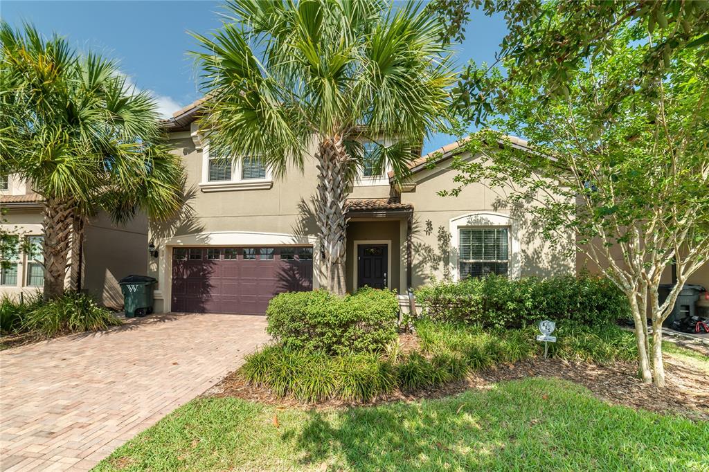 A two-story suburban house features a brick driveway, a palm tree, and a garage — 2137 MALTA TERRACE, KISSIMMEE, FL