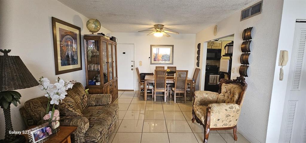A living and dining area features tile flooring, a ceiling fan, and traditional wood furniture — 6831 W 14 COURT UNIT 306, HIALEAH, FL