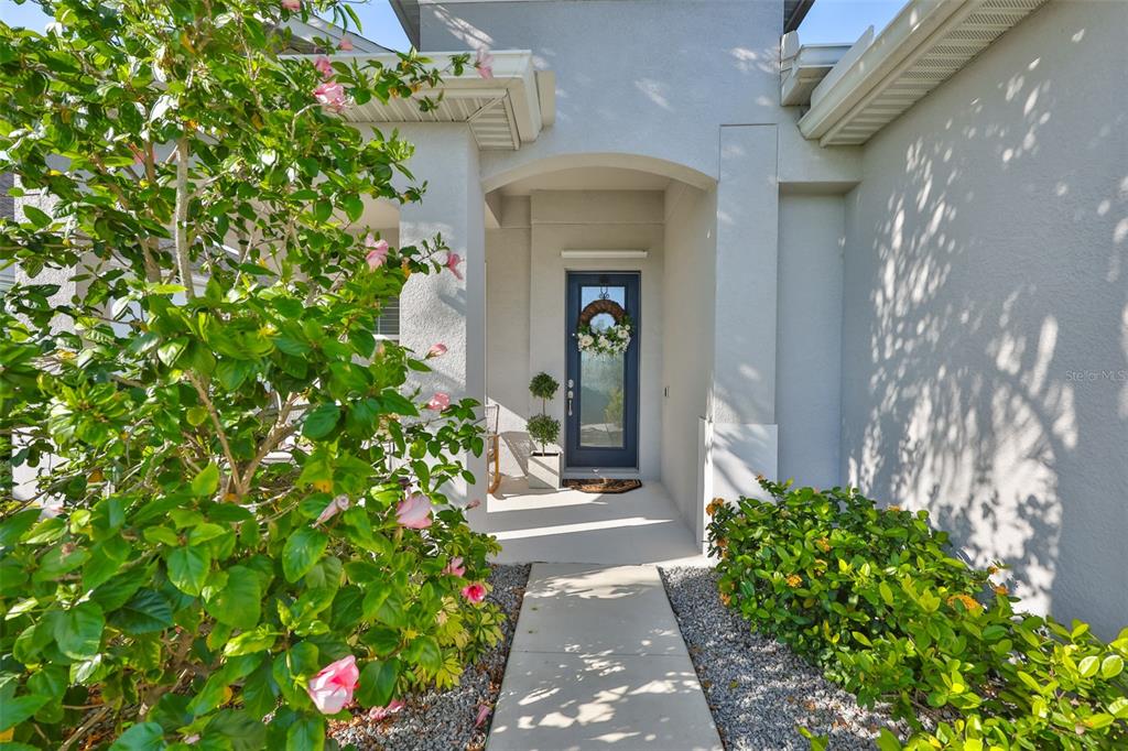 A concrete walkway leads to the front entrance of a house with a blue door — 12421 GLENRIDGE LANE, PARRISH, FL