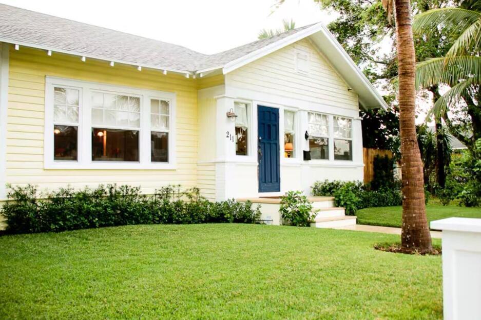 A yellow house with white trim, a blue front door, and a manicured front lawn — 211 N Ocean Breeze # 1, FL 33460, FL