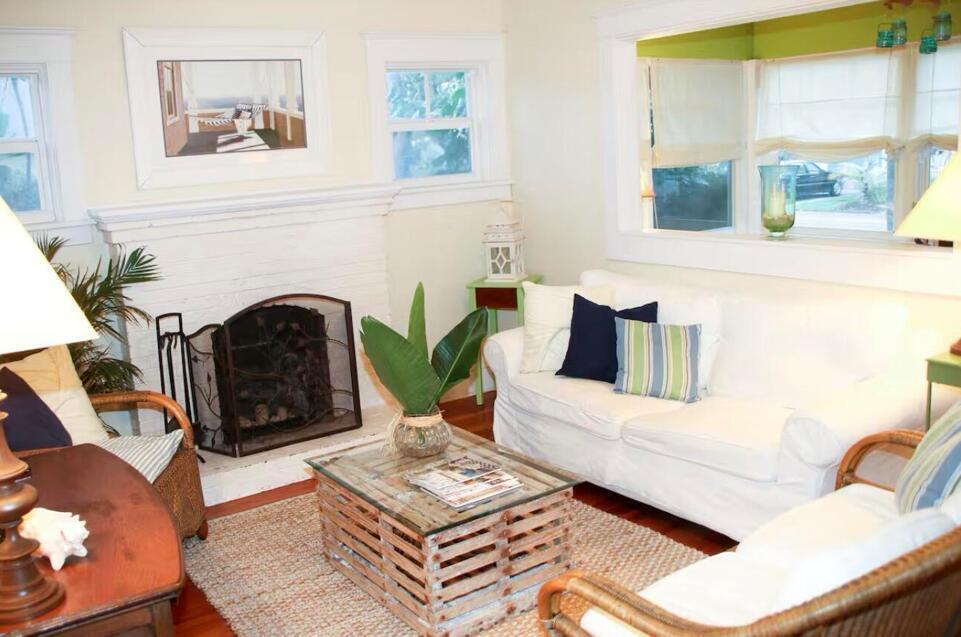 A living room features a white fireplace, a glass-topped crate coffee table, and white sofas — 211 N Ocean Breeze # 1, FL 33460, FL