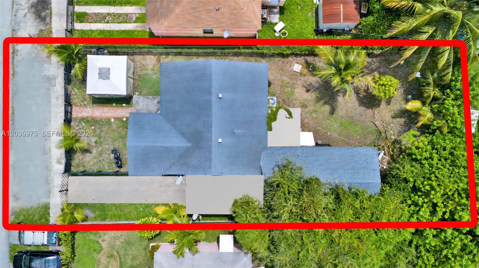An aerial view shows a residential house with a gray roof and a fenced yard — 1042 NW 76th St, Miami FL 33150, MIAMI, FL