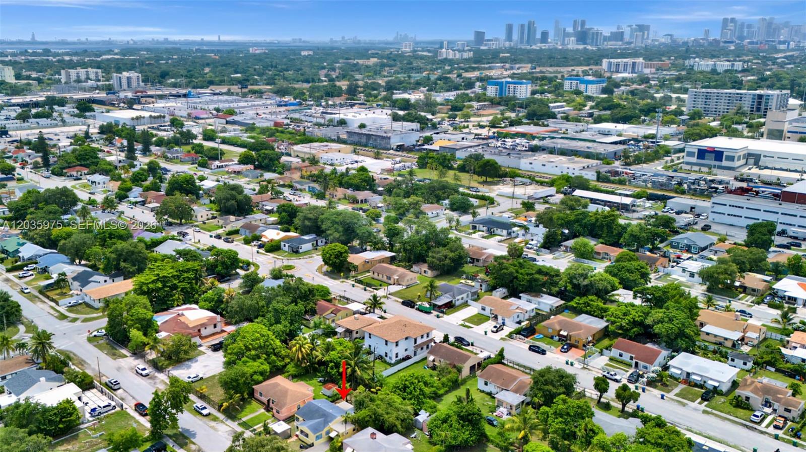An aerial view shows a residential neighborhood with a red arrow pointing to a house — 1042 NW 76th St, Miami FL 33150, MIAMI, FL