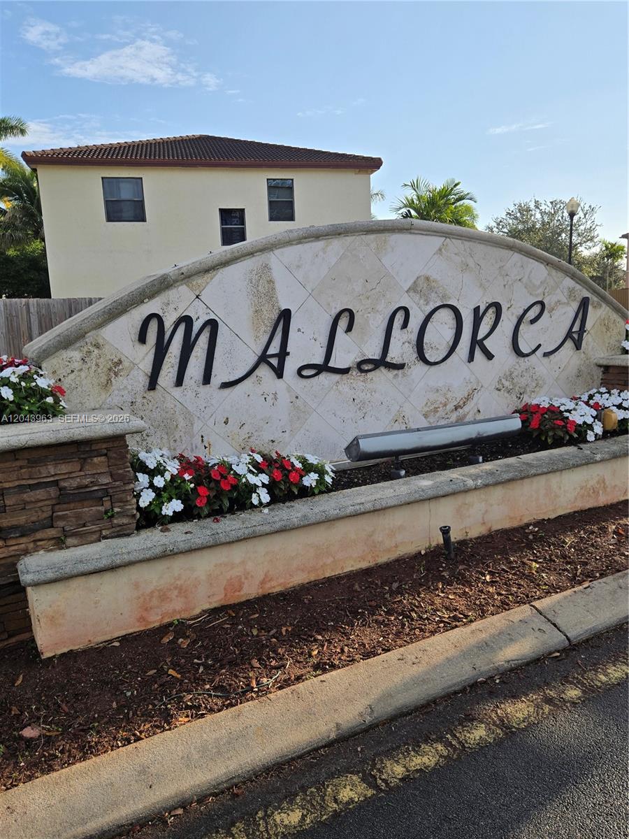 A stone community entrance sign for Mallorca sits in front of a two-story residential building — 634 SE 37 Ave, Homestead FL 33033, HOMESTEAD, FL