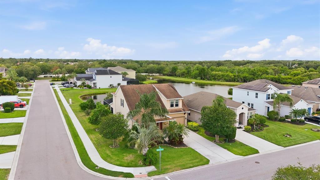 An aerial view of a two-story suburban house with a driveway, lawn, and palm trees — 4718 GARDEN ARBOR WAY, BRADENTON, FL