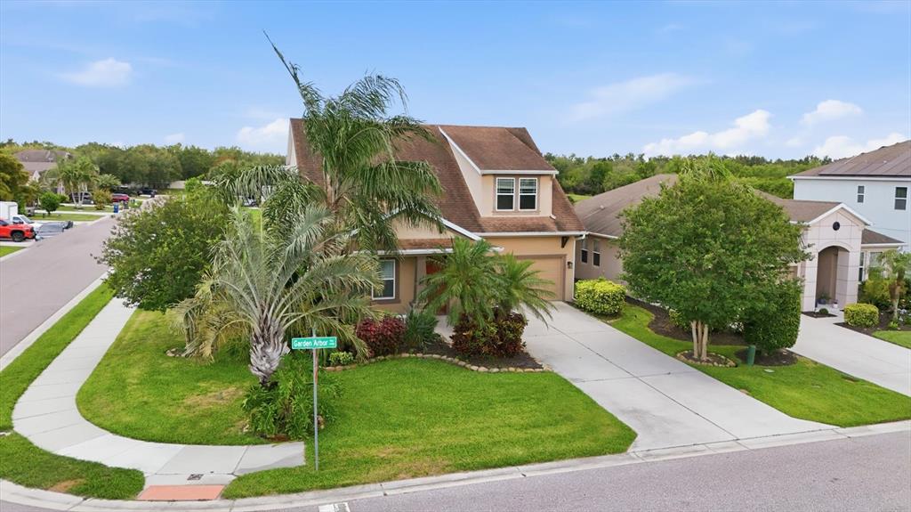 An aerial view shows a two-story suburban house with a driveway and a nearby pond — 4718 GARDEN ARBOR WAY, BRADENTON, FL