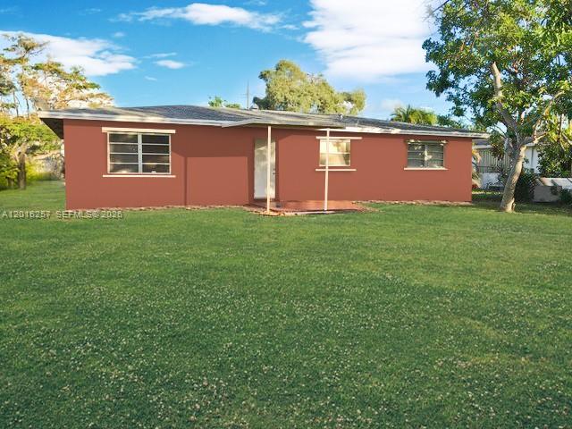 A single-story house with a reddish-brown exterior sits on a large, grassy lawn — 165 SE 4 AVENUE # 165, Deerfield Beach FL 33441, DEERFIELD BEACH, FL