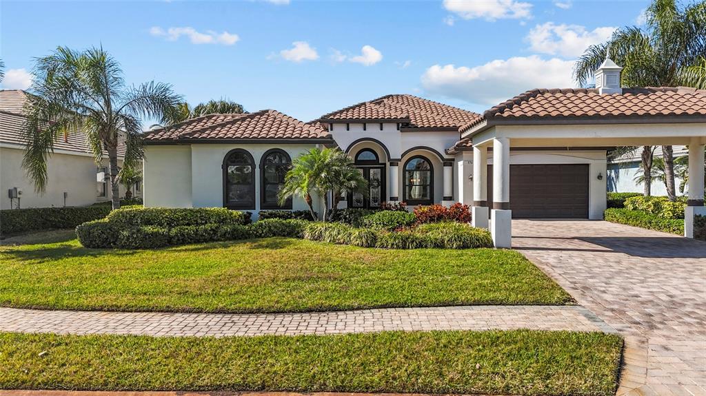 A single-story house with a tiled roof, arched windows, and a paved driveway — 576 MAST DRIVE, BRADENTON, FL