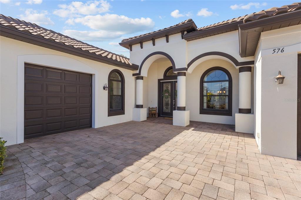 The exterior of a house features a paved driveway, arched entryway, and a garage door — 576 MAST DRIVE, BRADENTON, FL