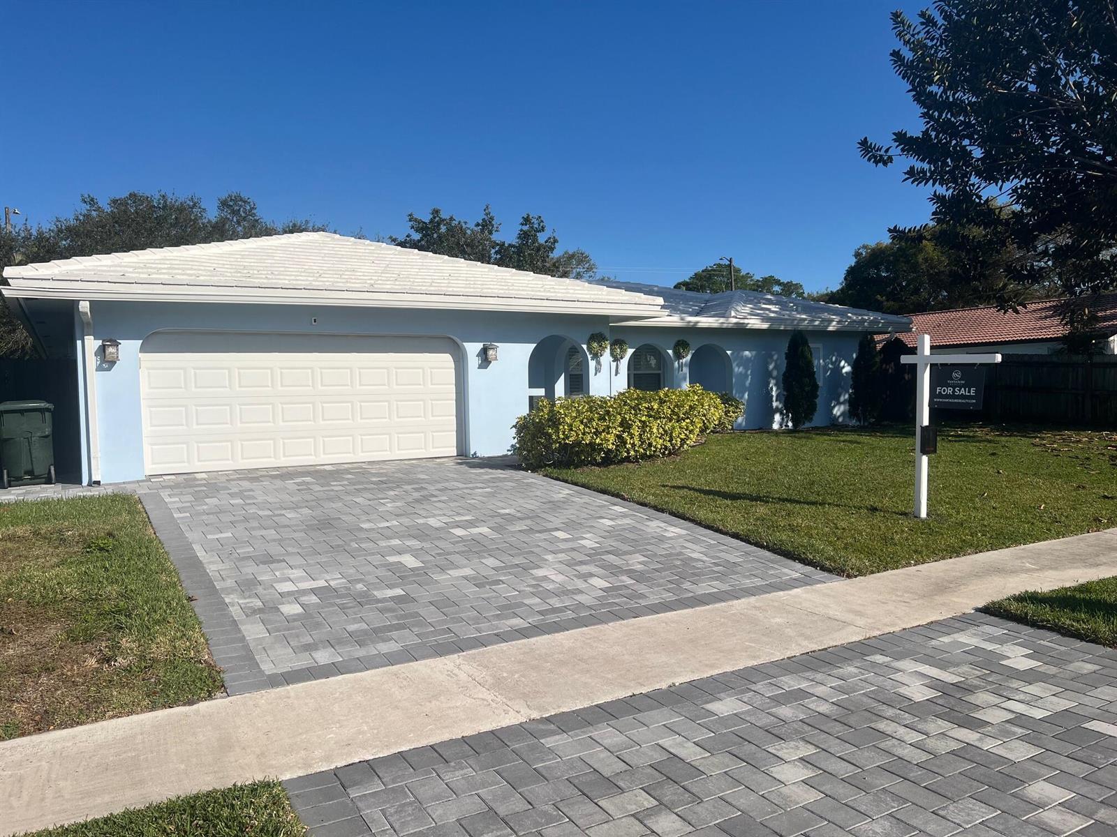 A light blue single-story house features a white tiled roof and a paved driveway — 3244 NW 25th Way, Boca Raton FL 33434, BOCA RATON, FL