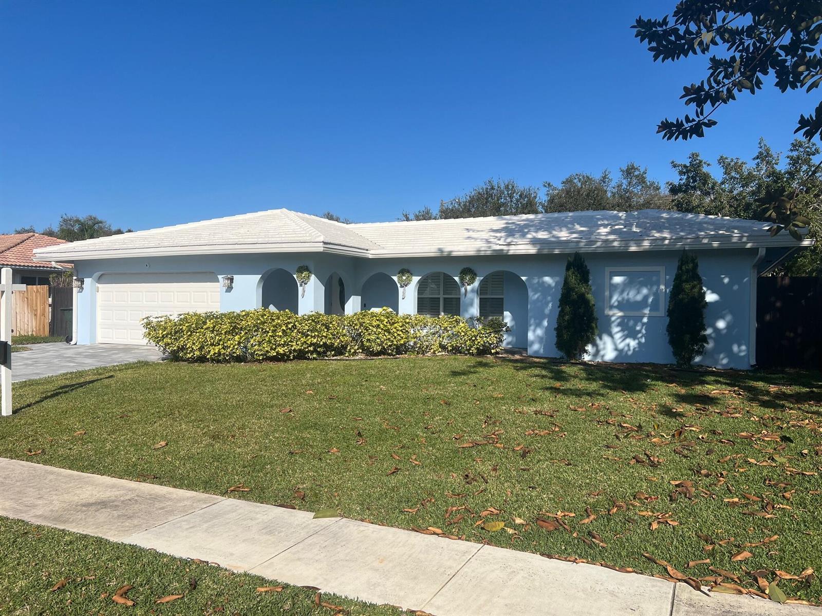 A light blue single-story house with a white roof, arched entryway, and a front lawn — 3244 NW 25th Way, Boca Raton FL 33434, BOCA RATON, FL
