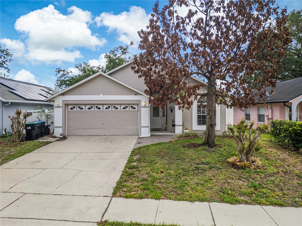 A single-story house with a beige exterior, a two-car garage, and a front yard — 3013 CATHERINE WHEEL COURT, ORLANDO, FL