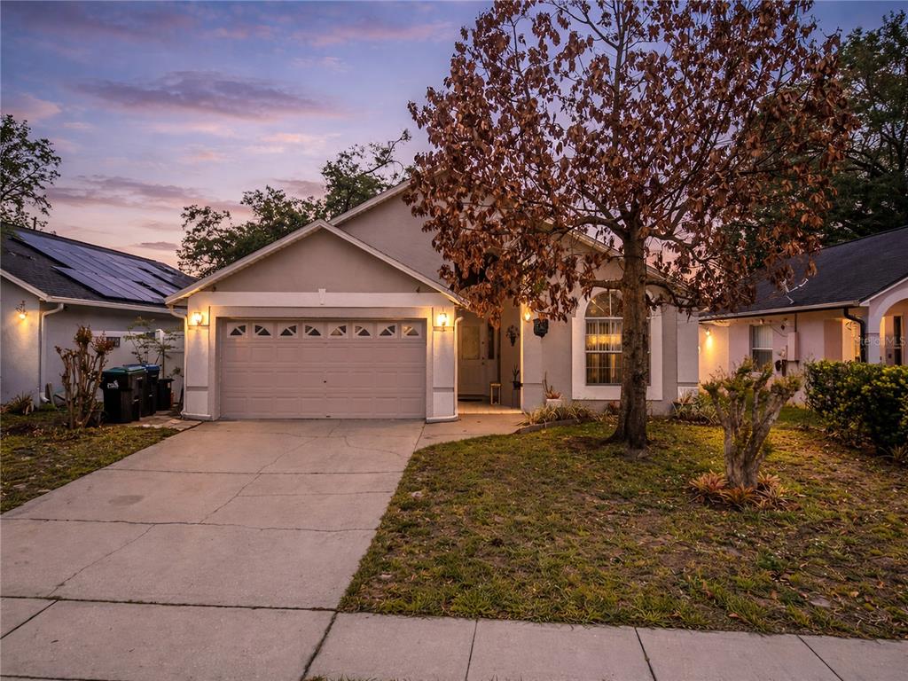 A single-story house with a beige exterior, a two-car garage, and a large front tree — 3013 CATHERINE WHEEL COURT, ORLANDO, FL