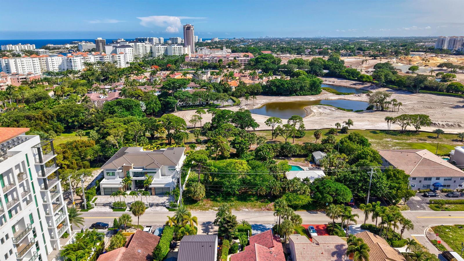 An aerial view shows a modern house, surrounding residential properties, and a nearby pond — 442 E Royal Palm Road, Boca Raton FL 33432, BOCA RATON, FL