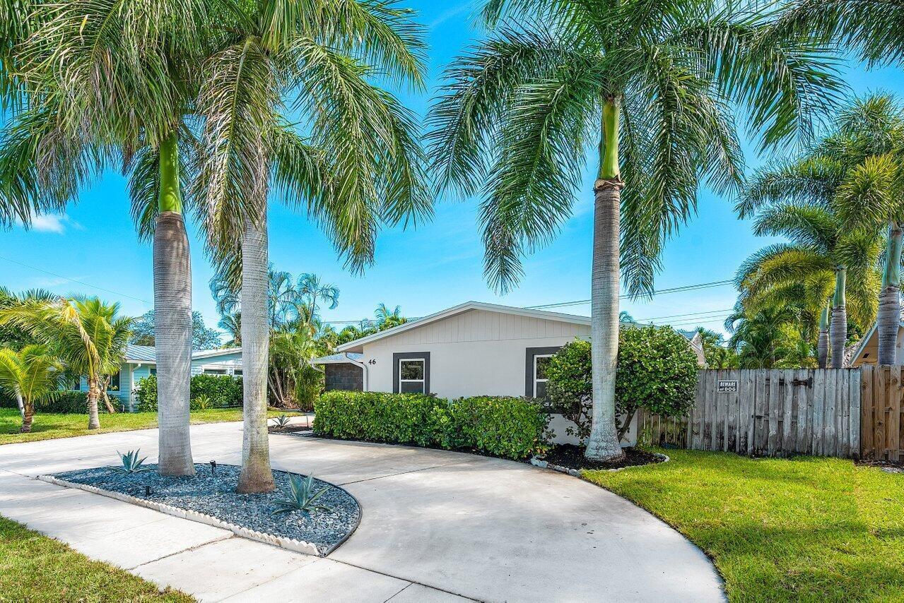A single-story house with a concrete driveway, palm trees, and a wooden fence — 46 SW 9th Avenue, Boca Raton FL 33486, BOCA RATON, FL
