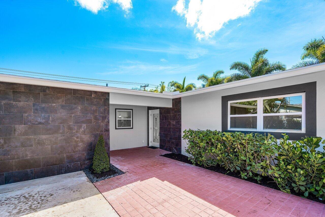 A modern house exterior features a red brick walkway, dark stone siding, and palm trees — 46 SW 9th Avenue, Boca Raton FL 33486, BOCA RATON, FL
