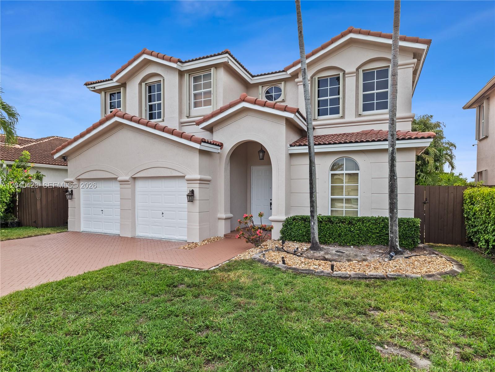 A two-story stucco house with a tiled roof, two-car garage, and a landscaped front yard — 8542 NW 111th Ct, Doral FL 33178, DORAL, FL