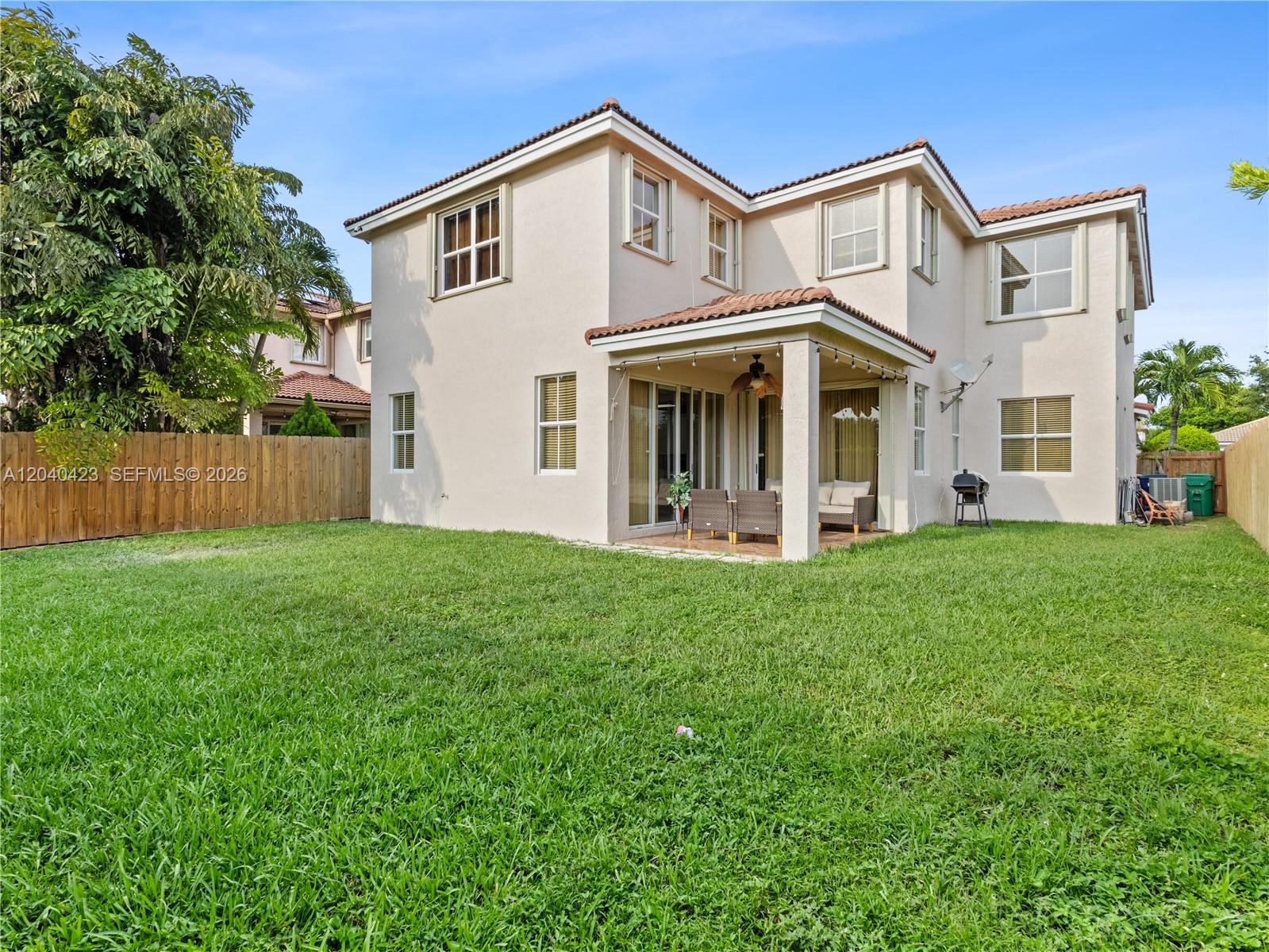 A two-story stucco house with a tiled roof and a covered patio overlooks a lawn — 8542 NW 111th Ct, Doral FL 33178, DORAL, FL