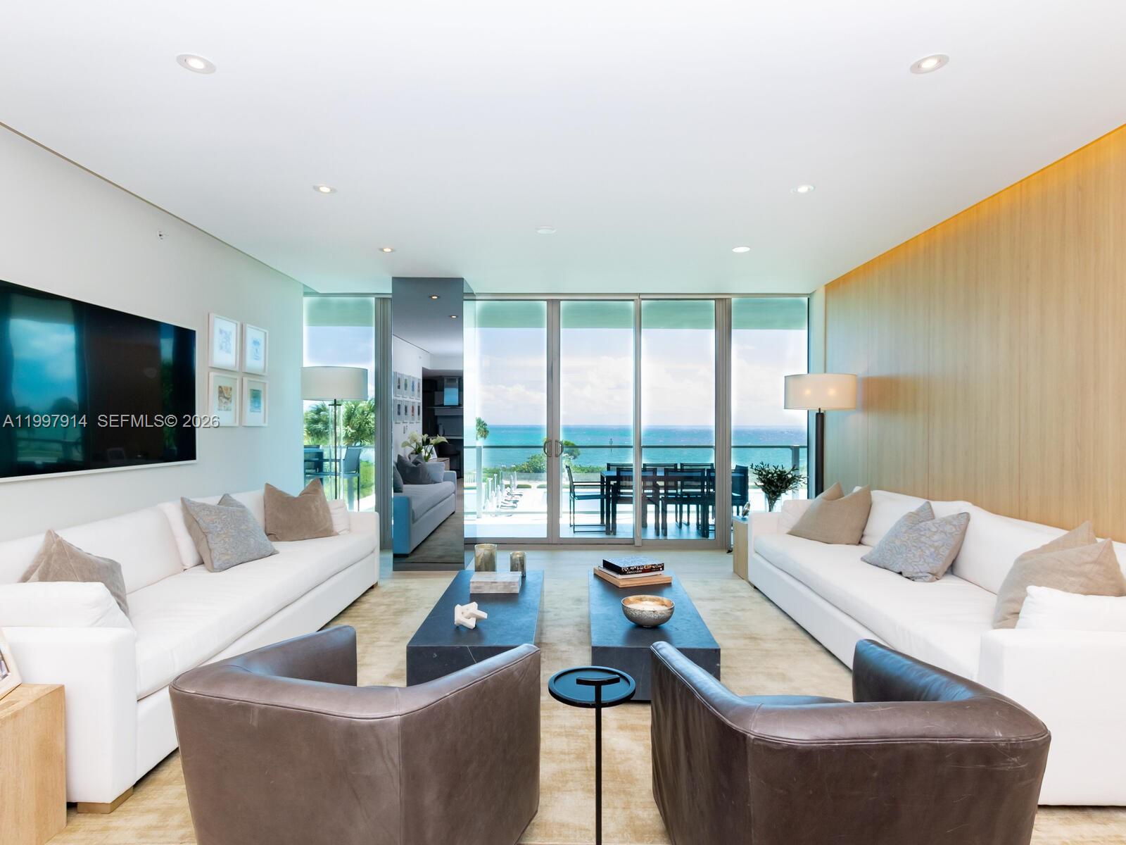 A living room features two white sofas, leather armchairs, and floor-to-ceiling windows overlooking the ocean — 360 Ocean Dr # 304S, Key Biscayne FL 33149, KEY BISCAYNE, FL