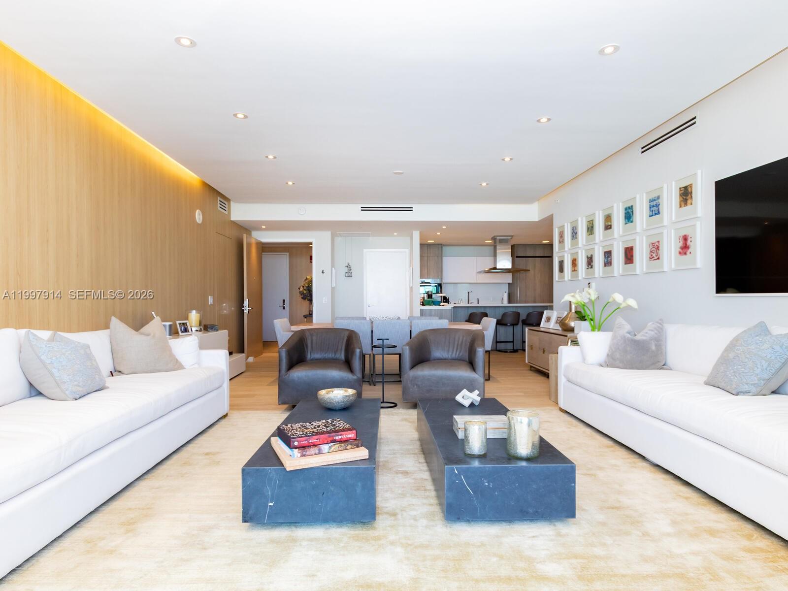 A modern living room features two white sofas, dark coffee tables, and wood-paneled walls — 360 Ocean Dr # 304S, Key Biscayne FL 33149, KEY BISCAYNE, FL
