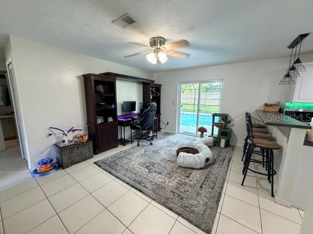 A living room features a desk, a large area rug, and a kitchen breakfast bar — 706 VENTERS STREET, PORT ORANGE, FL