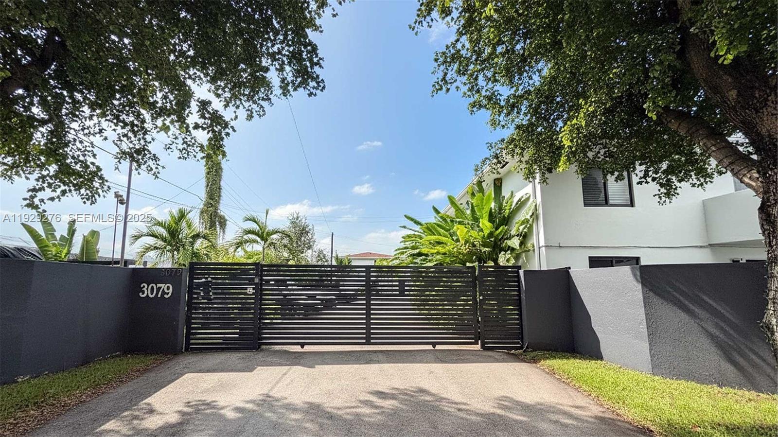 A gated entrance with a dark horizontal fence and a white building behind it — 3079 NW 11th St # 3053, Miami FL 33125, MIAMI, FL
