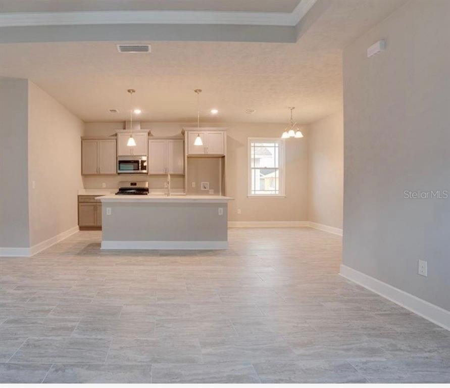 A kitchen with light gray cabinets, a center island, and tile flooring in an open room — 24339 SW 18TH LANE, NEWBERRY, FL