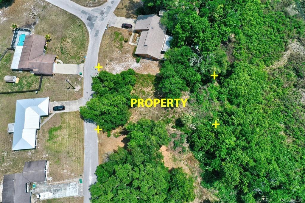 This aerial view shows a vacant, wooded residential lot situated between two existing houses — 9390 E MISTWOOD DRIVE, INVERNESS, FL