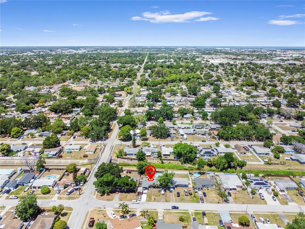 An aerial view shows a residential neighborhood with a red pin marking a single-family home — 5771 91ST AVENUE N, PINELLAS PARK, FL