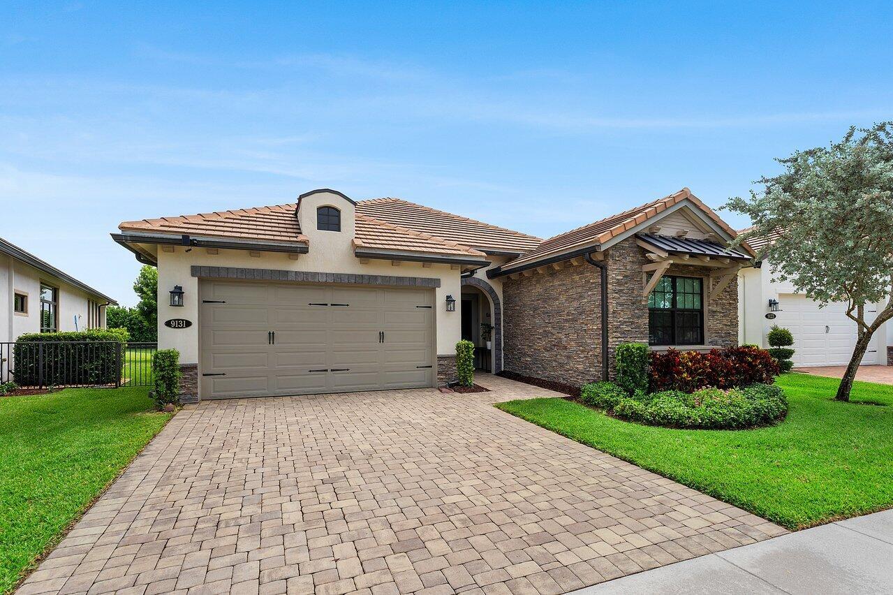 A single-story house with a stone facade, a tiled roof, and a paved driveway — 9131 Grand Prix Lane, Boynton Beach FL 33472, BOYNTON BEACH, FL
