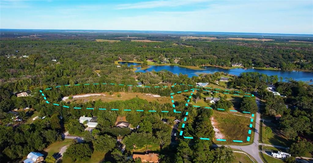 An aerial view shows a large, partially wooded plot of land outlined in blue — Lot 10 OVERLOOK DR, CHULUOTA, FL