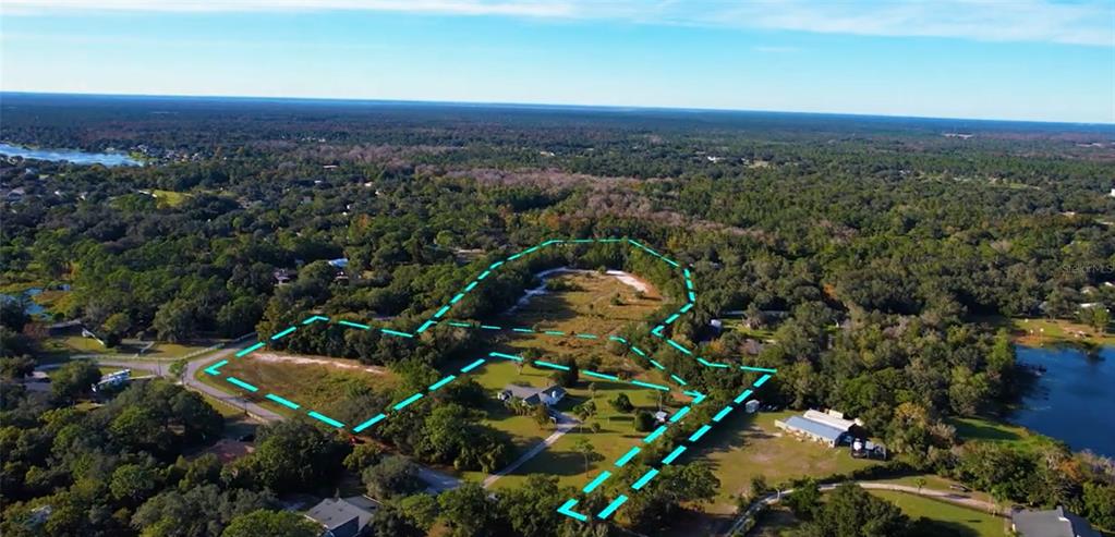 An aerial view shows a residential property with a house and large yard outlined in blue — Lot 10 OVERLOOK DR, CHULUOTA, FL