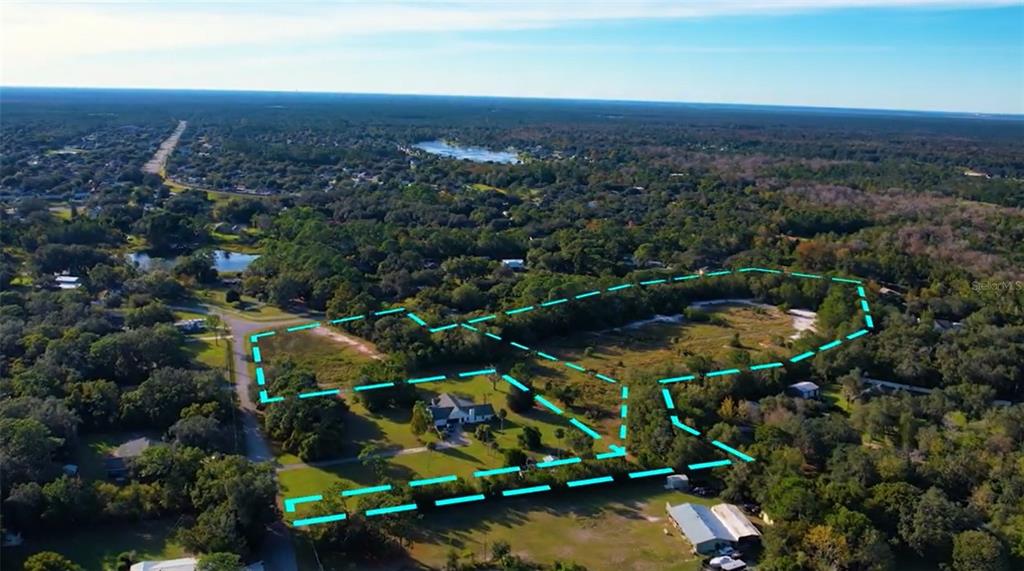 An aerial view shows a residential property outlined in blue, featuring a house and land — Lot 10 OVERLOOK DR, CHULUOTA, FL