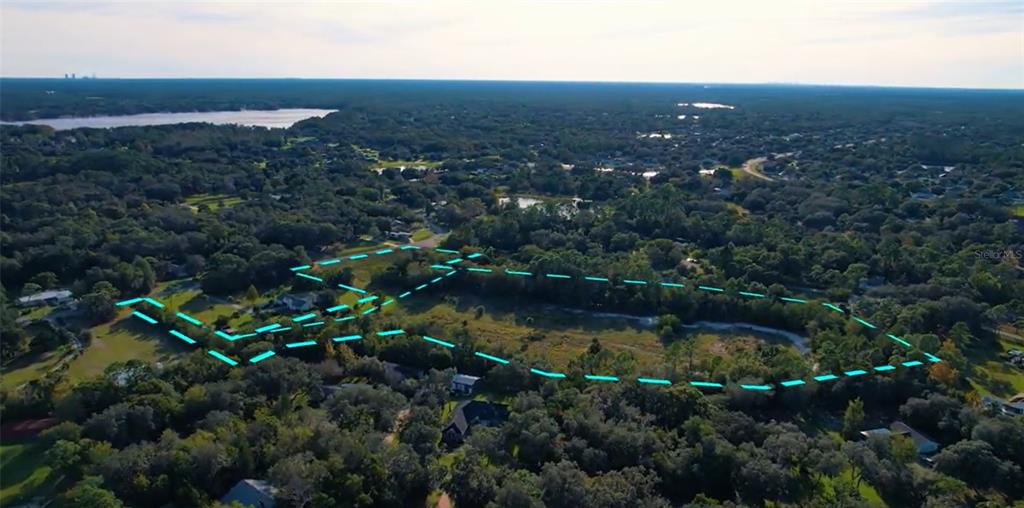 An aerial view shows a large, undeveloped plot of land outlined in blue — Lot 10 OVERLOOK DR, CHULUOTA, FL