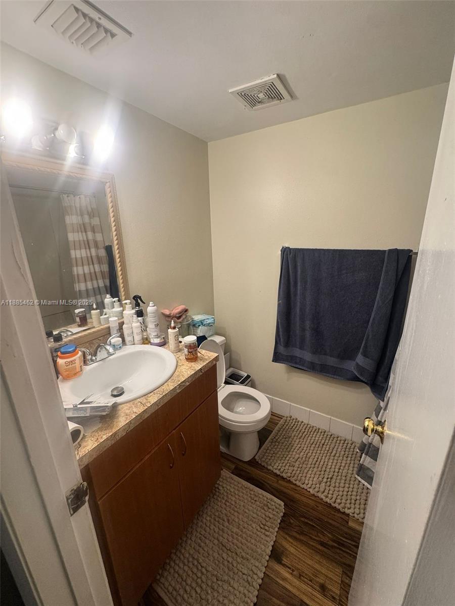 A bathroom features a wood vanity, a white sink, a toilet, and a blue towel — 6900 SW 39th St # 106J, Davie FL 33314, DAVIE, FL