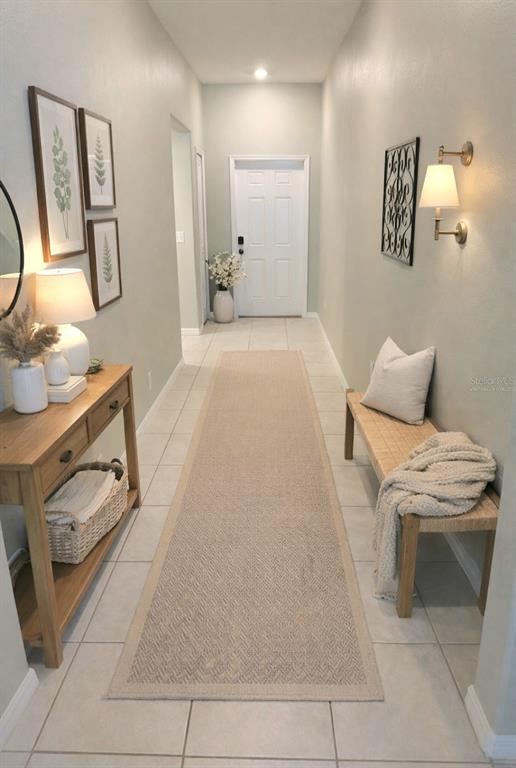 A bright entryway features a long runner rug, a wooden console table, and a bench — 10316 SHADY PRESERVE DRIVE, RIVERVIEW, FL