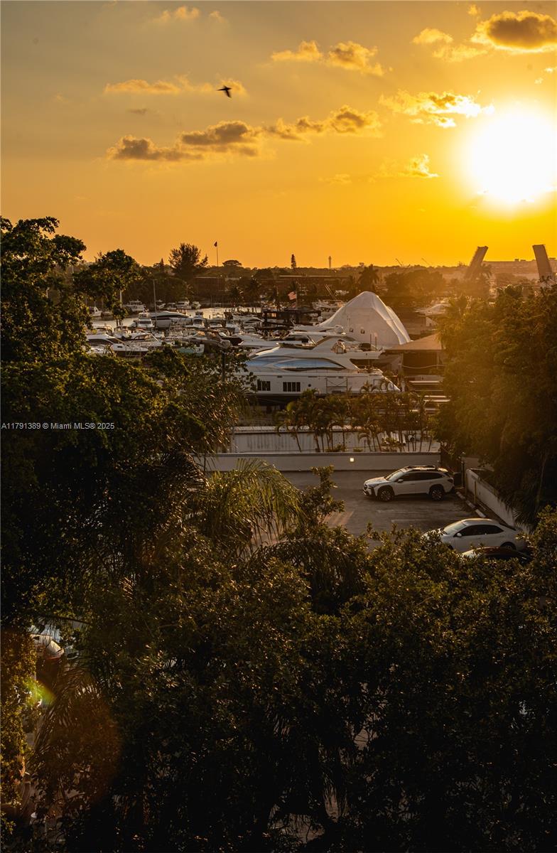 A sunset view overlooking a marina filled with yachts and a parking lot below — 1720 NW N River Dr # 607, Miami FL 33125, MIAMI, FL