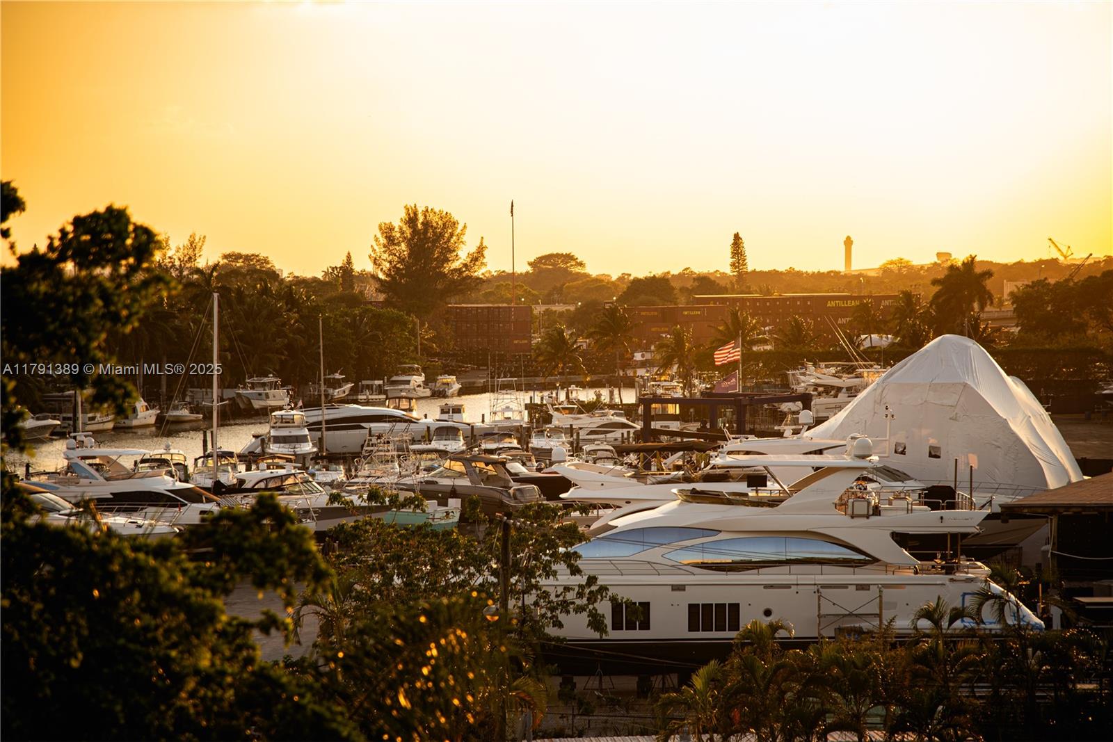 A marina filled with numerous yachts and boats at sunset under a golden sky — 1720 NW N River Dr # 607, Miami FL 33125, MIAMI, FL