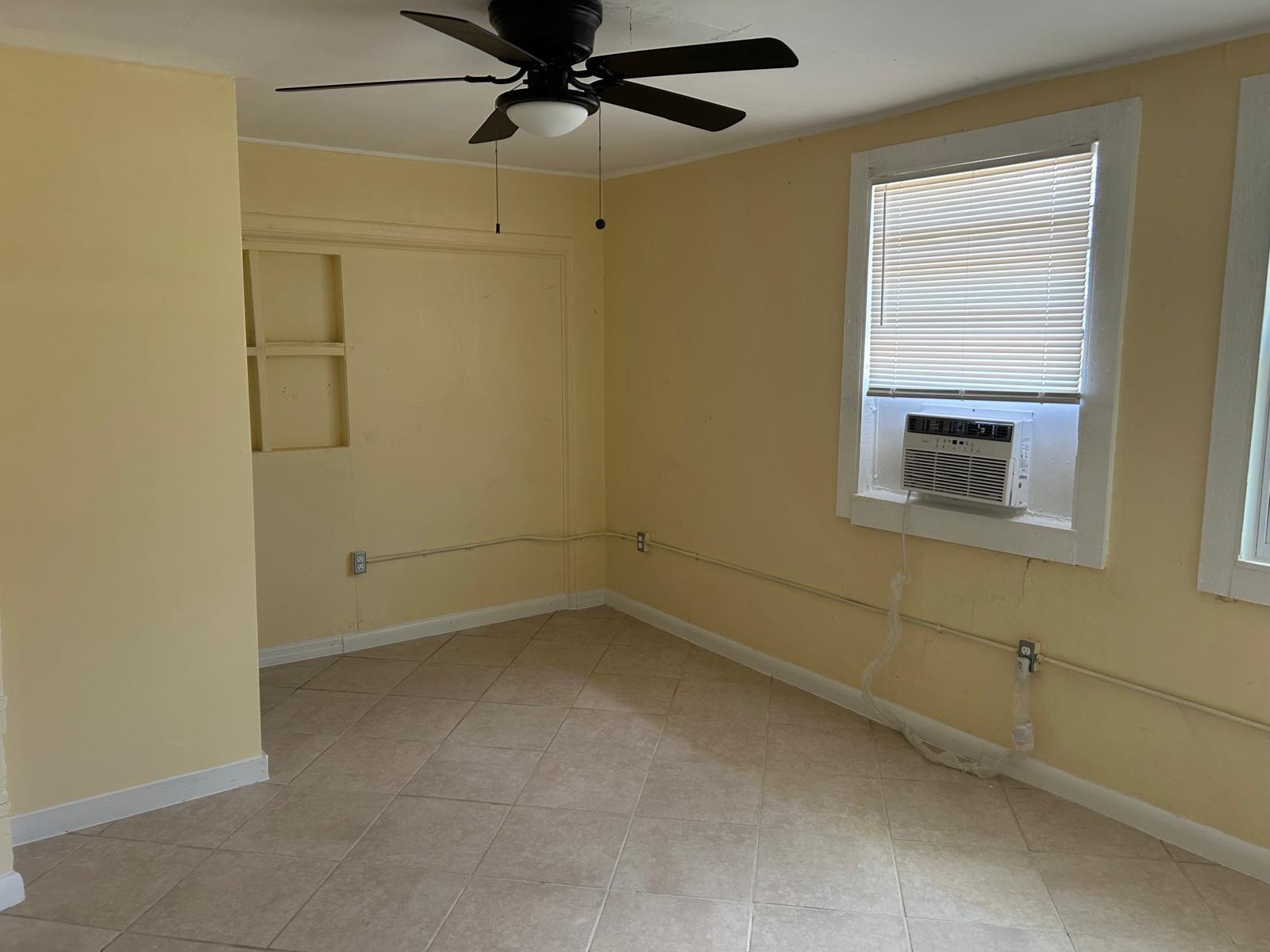 A room with yellow walls, tile flooring, a ceiling fan, and a window air conditioner — 371 Banyan Avenue, Pahokee FL 33476, PAHOKEE, FL