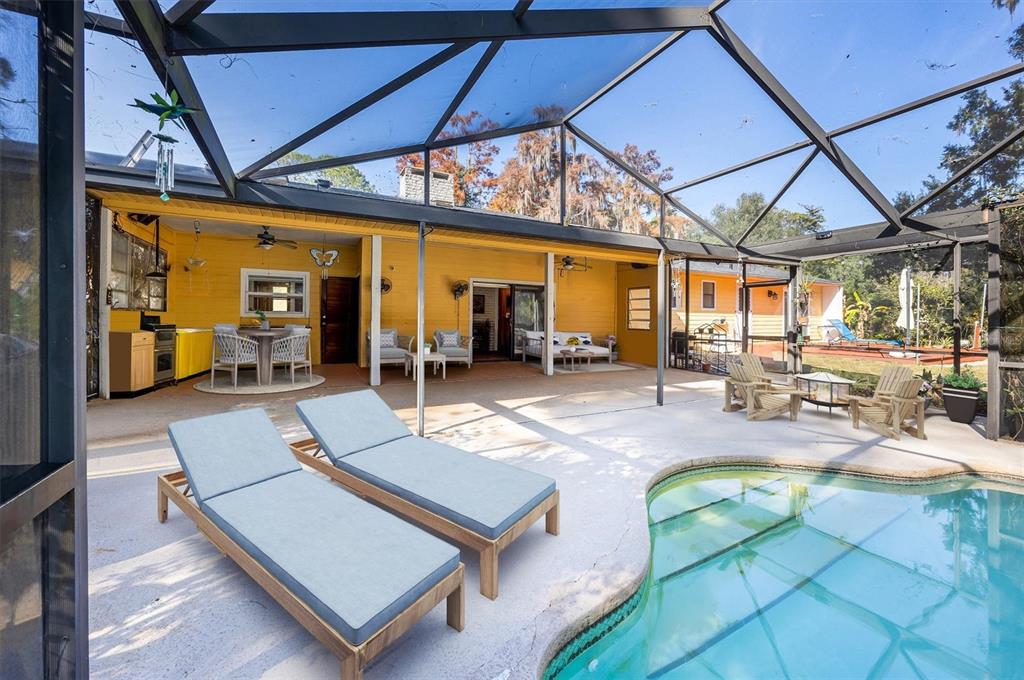 A screened-in patio features a swimming pool, lounge chairs, and a yellow exterior wall — 3811 SW 82ND STREET, GAINESVILLE, FL