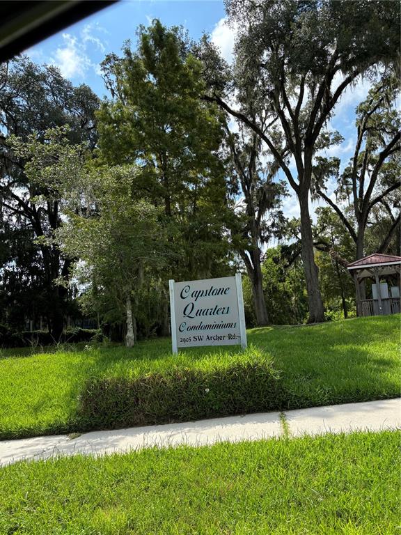 A sign for Capstone Quarters Condominiums stands on a grassy lawn near mature trees — 2905 SW ARCHER ROAD UNIT T4028, GAINESVILLE, FL
