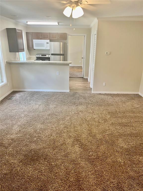 A carpeted living area opens to a kitchen with a breakfast bar and stainless appliances — 2905 SW ARCHER ROAD UNIT T4028, GAINESVILLE, FL