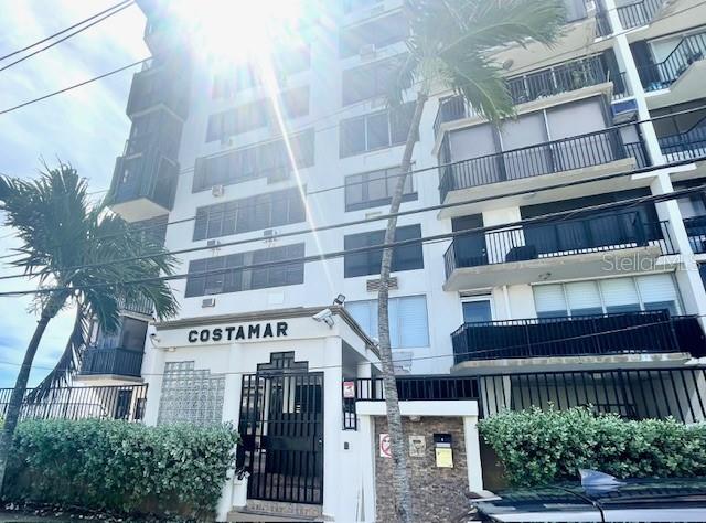 The exterior of the Costamar apartment building features white balconies and a gated entrance — 1 INGA STREET UNIT 6F, SAN JUAN, PR