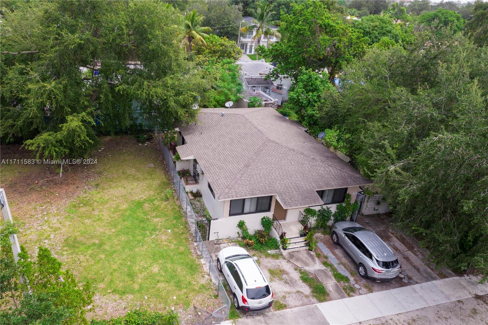 An aerial view shows a single-story house with a large side yard and two parked cars — 175 NW 68th St, Miami FL 33150, MIAMI, FL