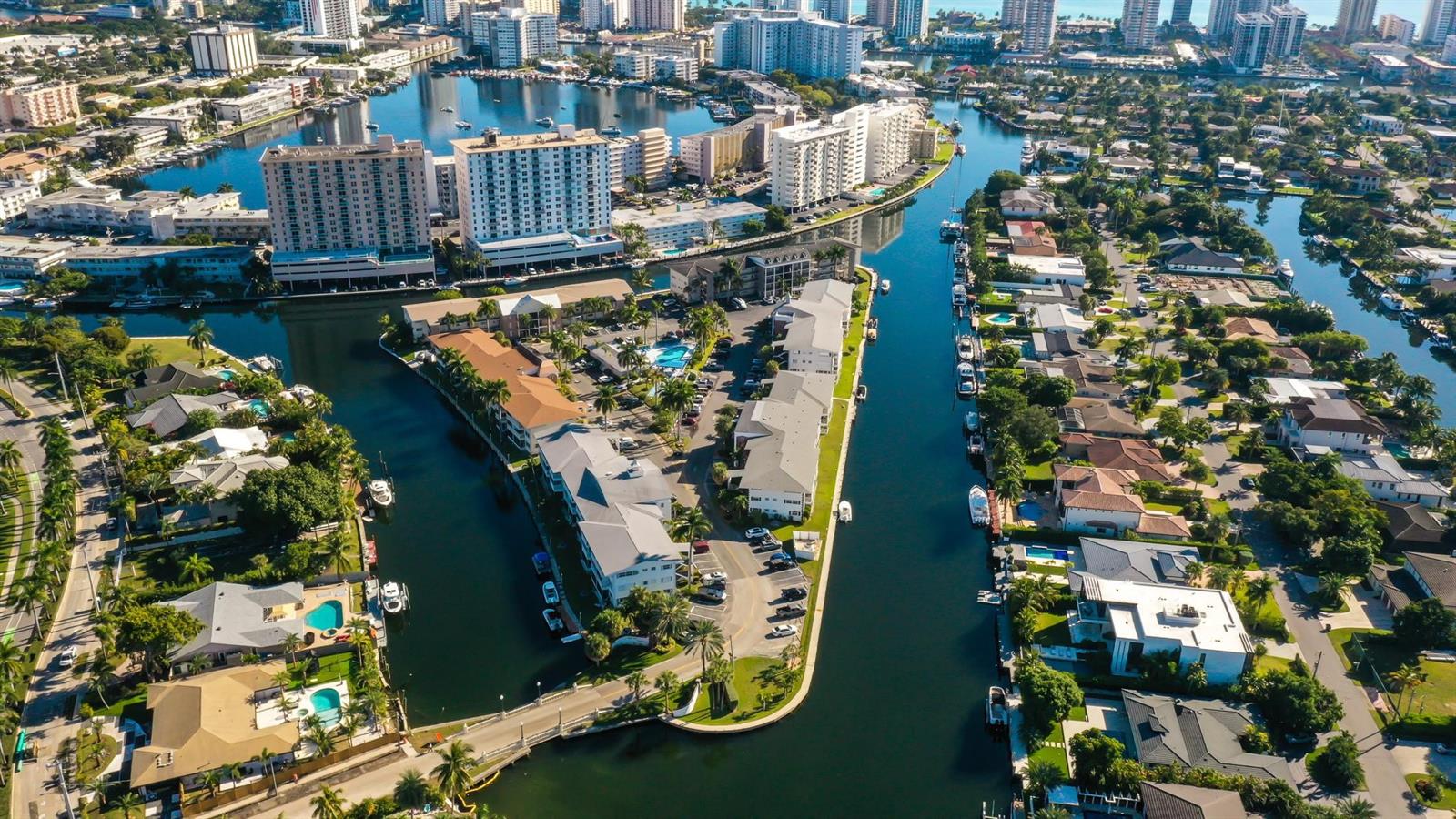 Aerial view of a waterfront residential neighborhood with canals, apartment buildings, and single-family homes — 450 Paradise Isle Boulevard, Hallandale Beach FL 33009, HALLANDALE BEACH, FL